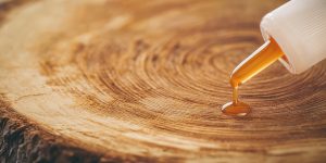 The thick glue is squeezed from the tube onto the wooden surface. Instant curing adhesive for various surfaces and wood.