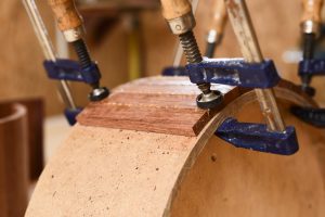 Part of handmade wooden drum held in clamp
