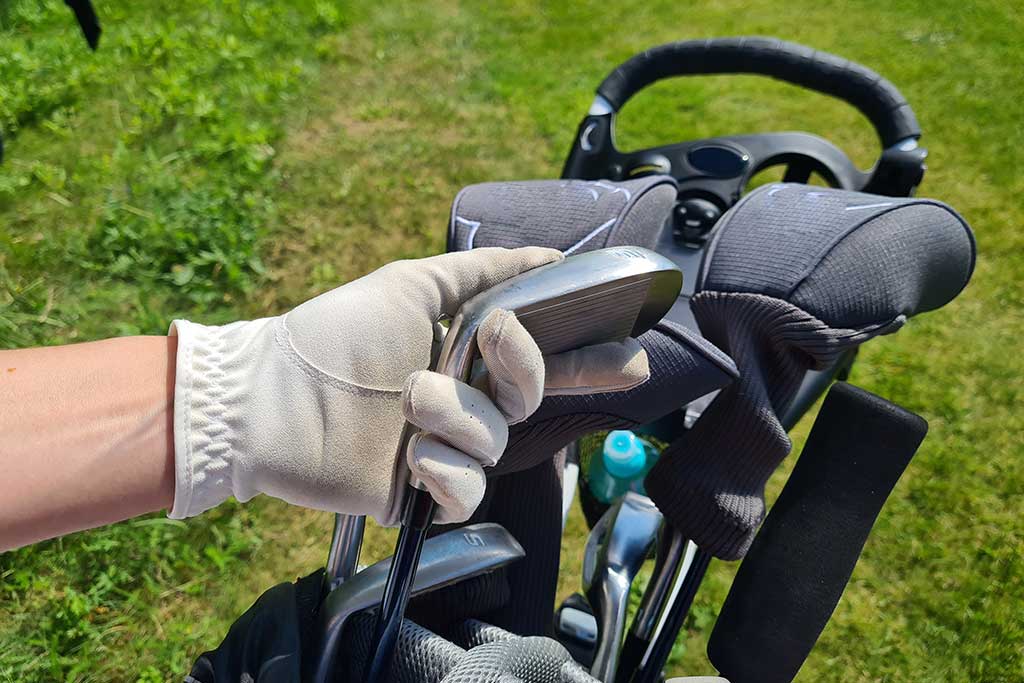 Professional golfer chooses golf club from bag